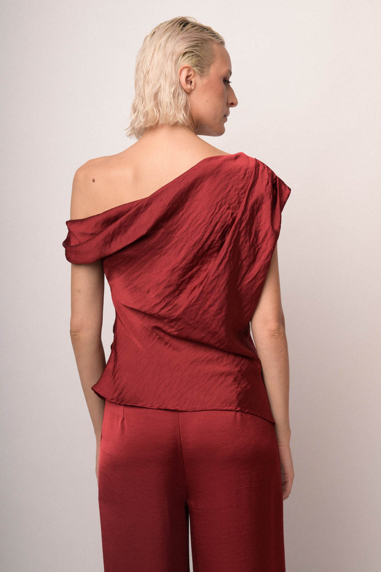 Top asimmetrico in raso bordeaux con spilla gioiello