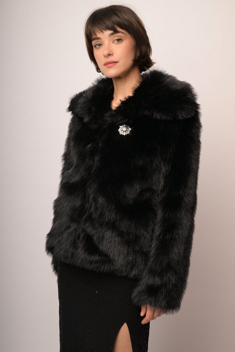 Giacca in faux fur nera con spilla gioiello