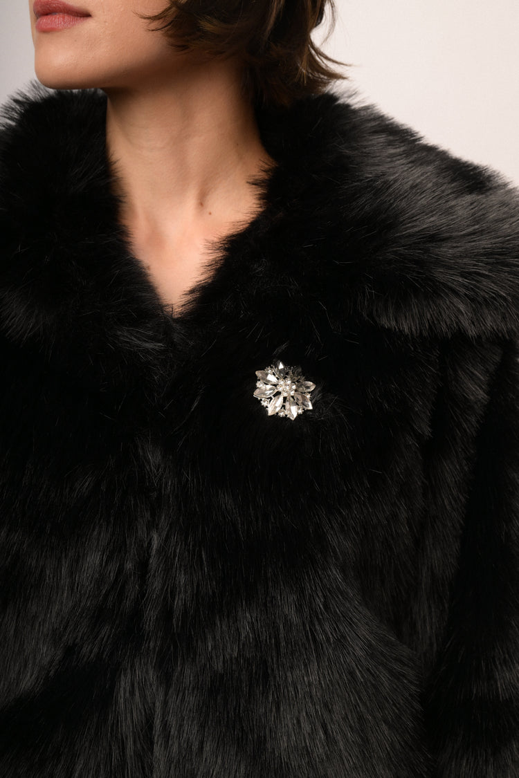 Giacca in faux fur nera con spilla gioiello
