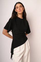 Maglia nera con arricciatura e fondo asimmetrico
