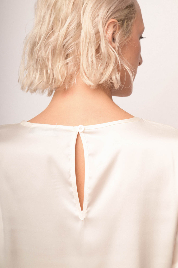 Blusa in raso bianco con scollo tondo profilato in strass
