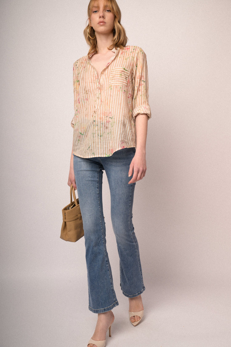 Jeans in denim azzurro a gamba svasata con bottoni gioiello