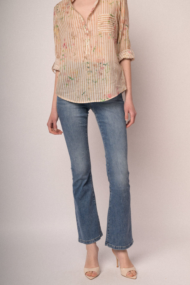 Jeans in denim azzurro a gamba svasata con bottoni gioiello