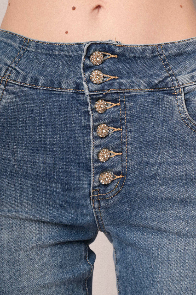 Jeans in denim azzurro a gamba svasata con bottoni gioiello