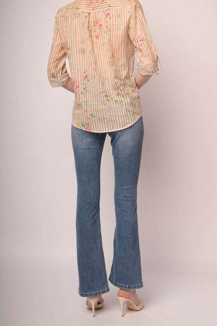 Jeans in denim azzurro a gamba svasata con bottoni gioiello
