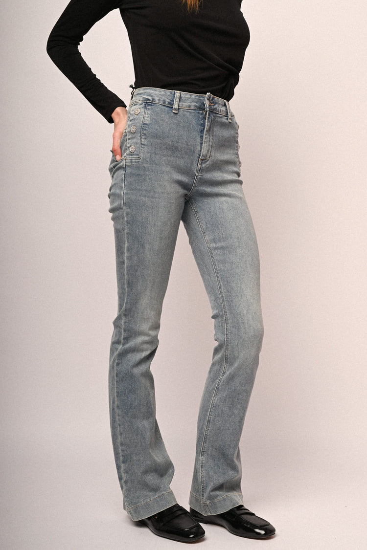 Jeans a gamba svasata in denim azzurro con bottoni gioiello