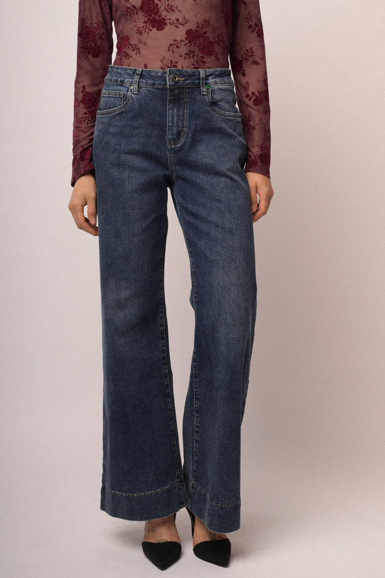Jeans in denim blu a gamba svasata con impuntura rossa
