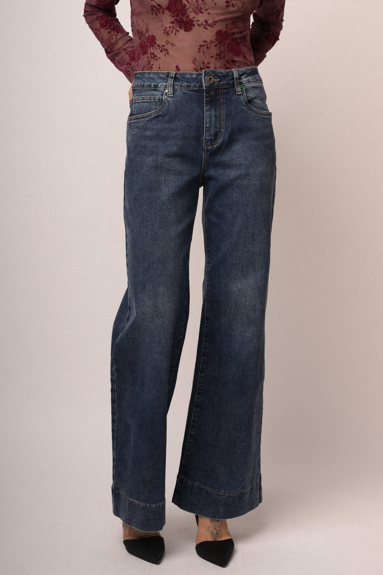 Jeans in denim blu a gamba svasata con impuntura rossa