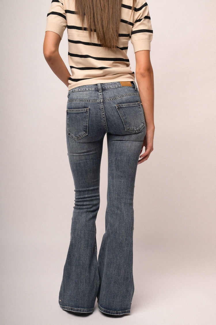 Jeans a gamba svasata in denim blu con stelle e strass