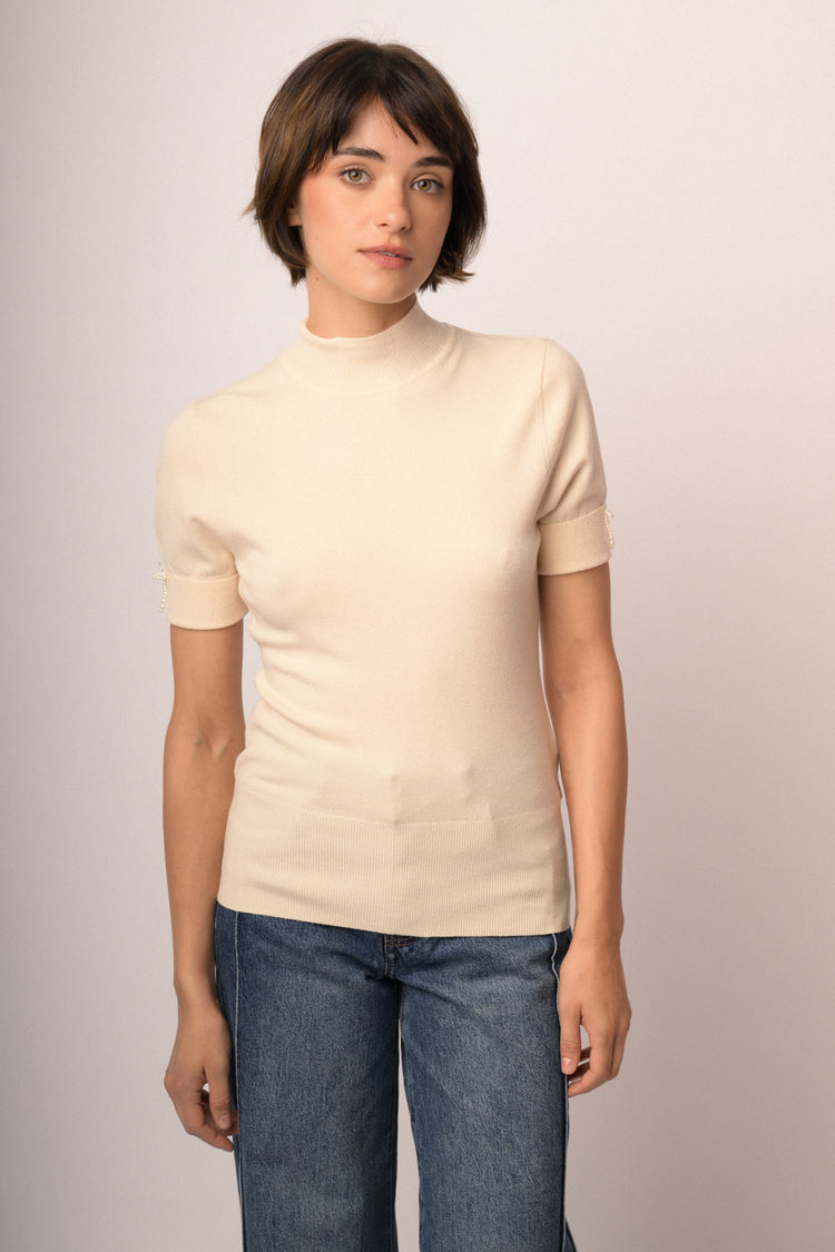 Lupetto in maglia beige con fiocchetti decorativi alle mezze maniche