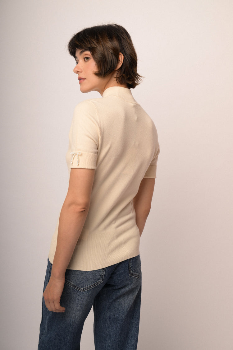 Lupetto in maglia beige con fiocchetti decorativi alle mezze maniche