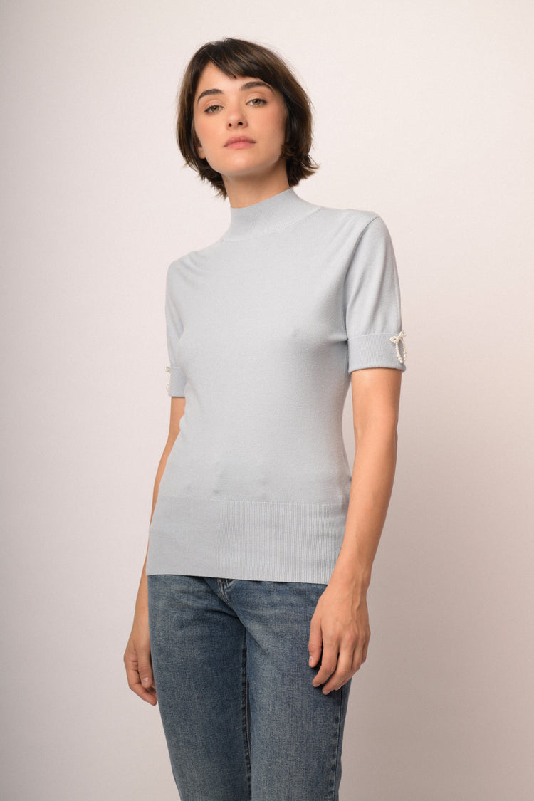 Lupetto in maglia celeste con fiocchetti decorativi alle mezze maniche