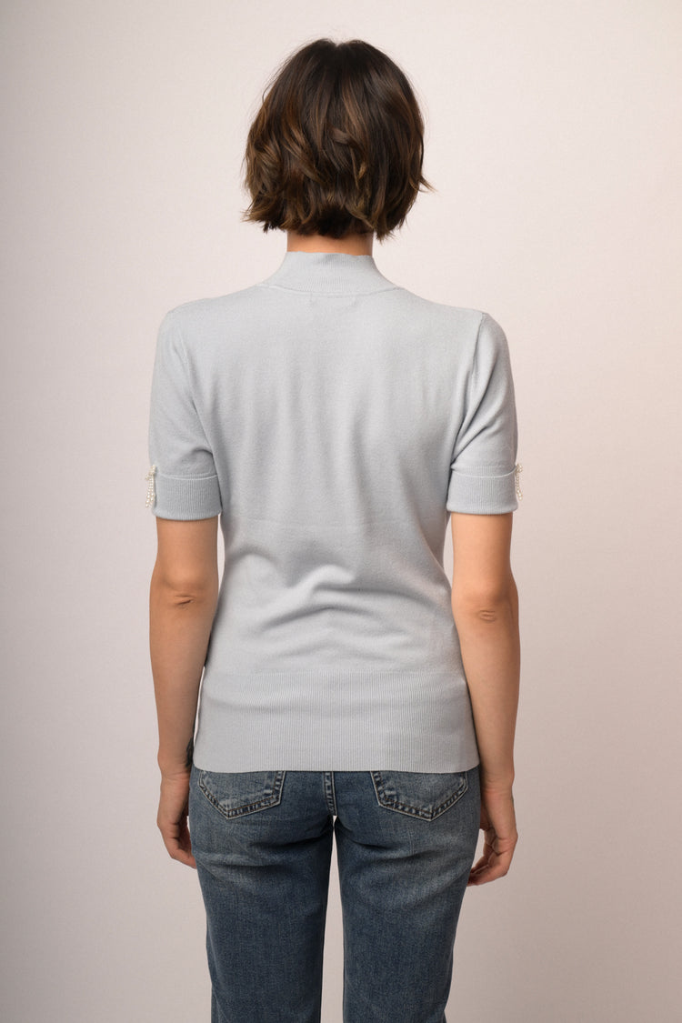 Lupetto in maglia celeste con fiocchetti decorativi alle mezze maniche
