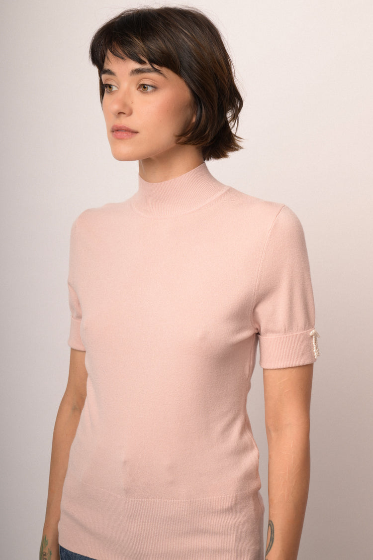 Lupetto in maglia rosa con fiocchetti decorativi alle mezze maniche