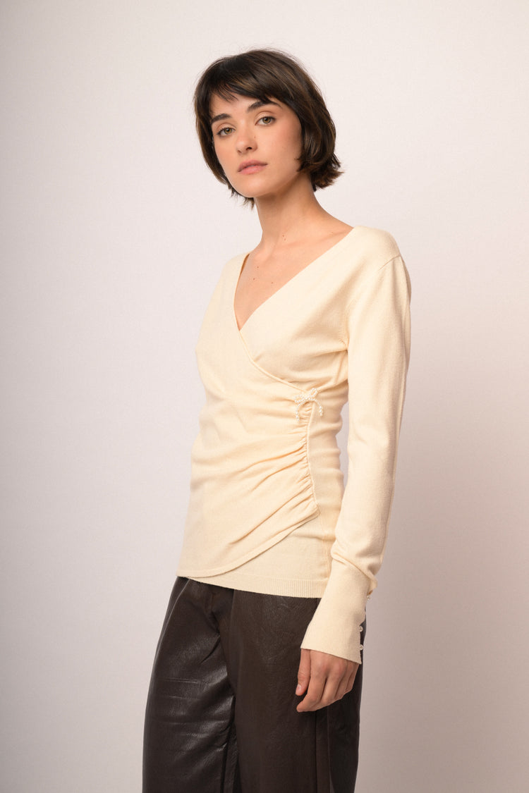 Pull incrociato avorio con fiocchetto in perline