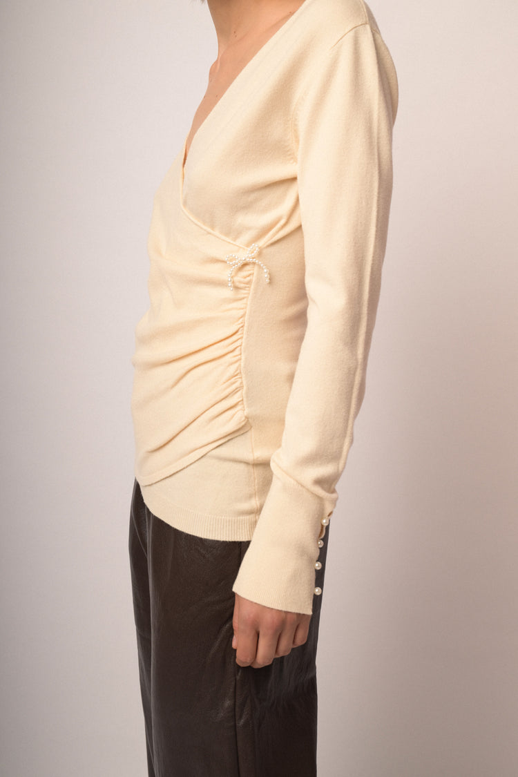 Pull incrociato avorio con fiocchetto in perline