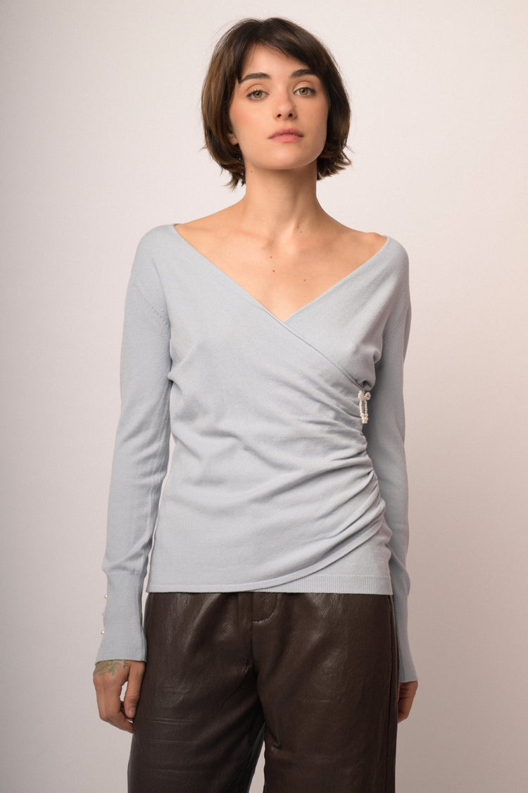 Pull incrociato celeste con fiocchetto in perline