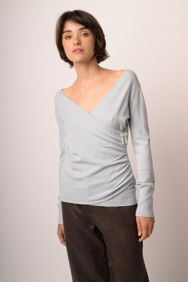 Pull incrociato celeste con fiocchetto in perline