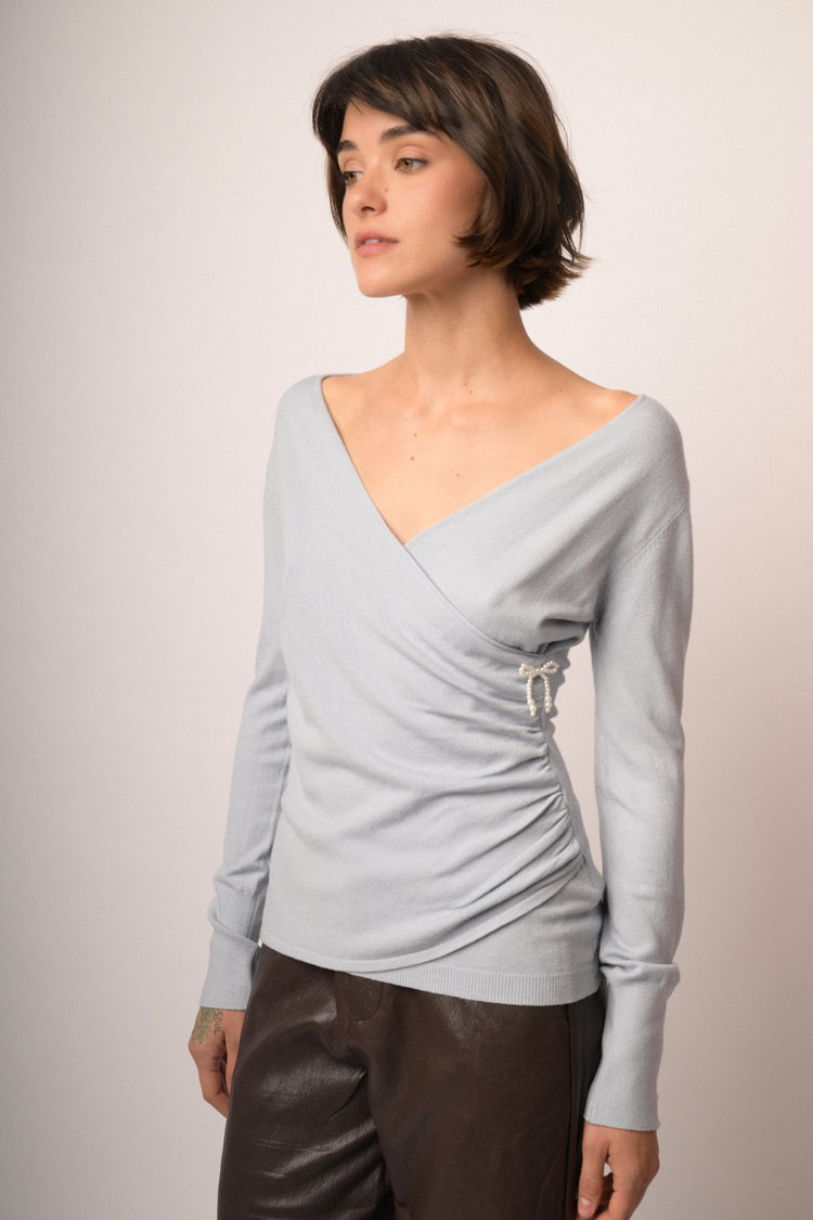 Pull incrociato celeste con fiocchetto in perline