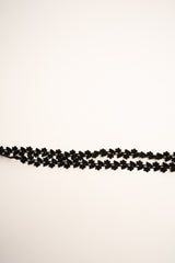 Cintura sottile in faux suede nera con motivo floreale e tasselli a frange