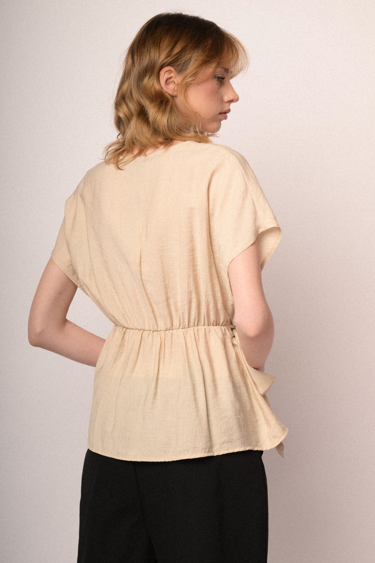 Top beige con scollo a V e fiocco da annodare